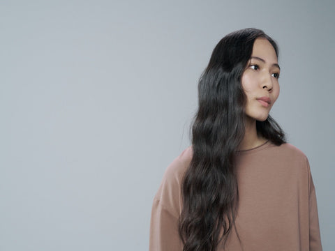 Woman with long, healthy hair demonstrating smooth, shiny hair after a balanced protein hair care routine.